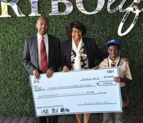 Derron Blake Jr., right, poses with Dr. Ben and Candy Carson and his $1,000 scholarship check.