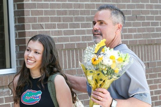 Niceville High School Principal Charlie Marello brings Niceville senior Laurel Wentworth to the school steps for a surprise celebration of her 2340 days of perfect school attendance. Michael Snyder, The Northwest Florida Daily News-USA TODAY NETWORK